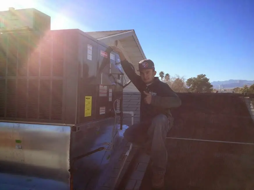 HVAC technician performing Heat Pump Repair on a rooftop unit in Fort Collins